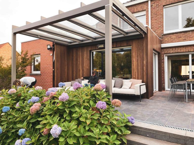 Weinor Glasoase door demaeght zonwering geplaatst aan deze gerenoveerde woning te Harelbeke. Een glasoase aanbouw met gevelrenovatie met de houten gevelbekleding van Carpentier. De Essen plus line profielen. Modern en strak design.