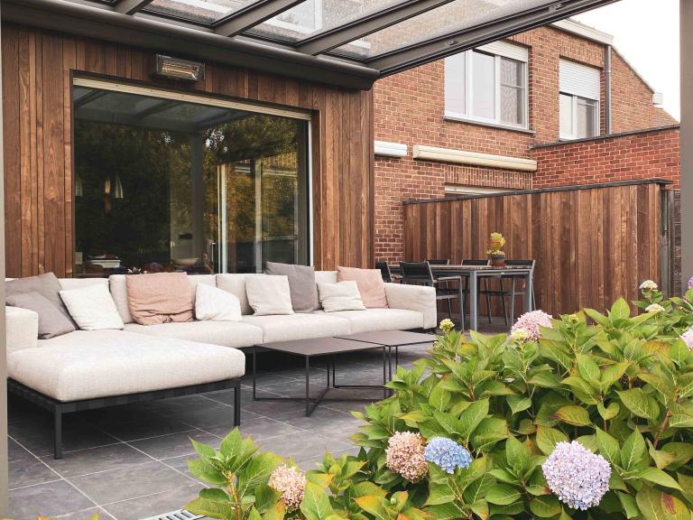 Weinor Glasoase door demaeght zonwering geplaatst aan deze gerenoveerde woning te Harelbeke. Een glasoase aanbouw met gevelrenovatie met de houten gevelbekleding van Carpentier. De Essen plus line profielen. Modern en strak design.