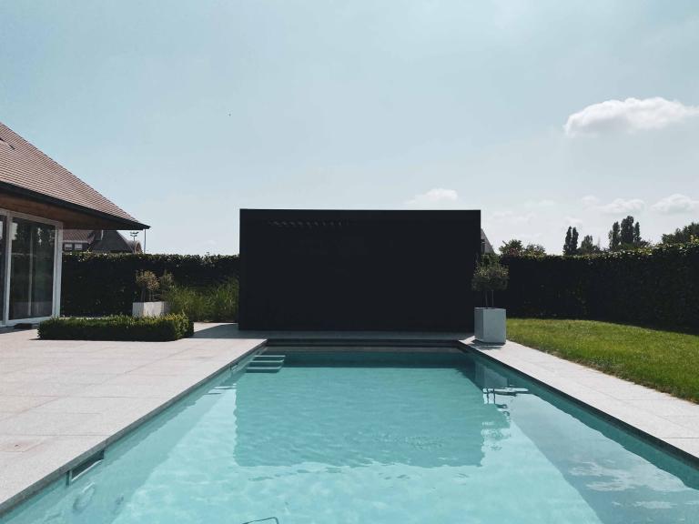 Demaeght Zonwering en interieur plaatse een Renson Camargue lamellendak aan dit zwembad te Waregem. Een buitenverblijf in eigen tuin. Een aluminium pergola volledig op maat naar wens van de klant. Modern en strak design. 