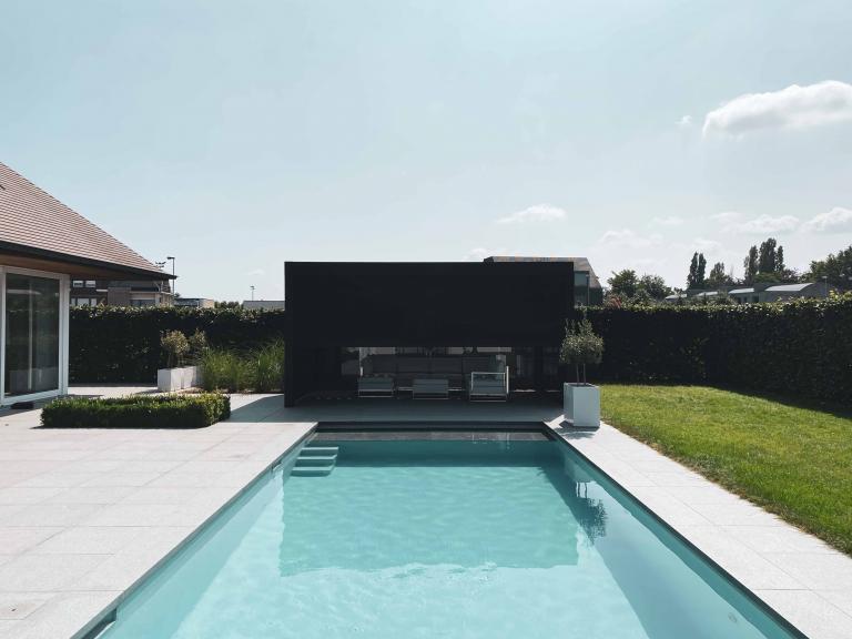 Demaeght Zonwering en interieur plaatse een Renson Camargue lamellendak aan dit zwembad te Waregem. Een buitenverblijf in eigen tuin. Een aluminium pergola volledig op maat naar wens van de klant. Modern en strak design. 