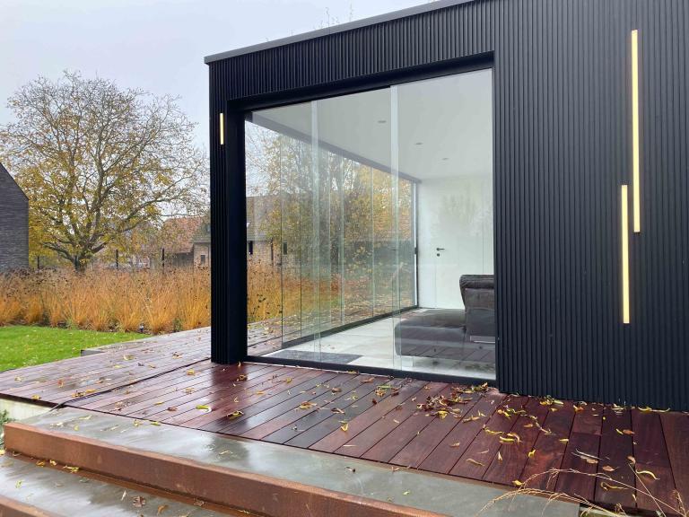 Demaeght zonwering plaatste een houten bijgebouw van Carpentier met Renson linarte gevelbekleding. een modern en strak design met warme accenten. Een eigen architecturaal outdoor creatie.