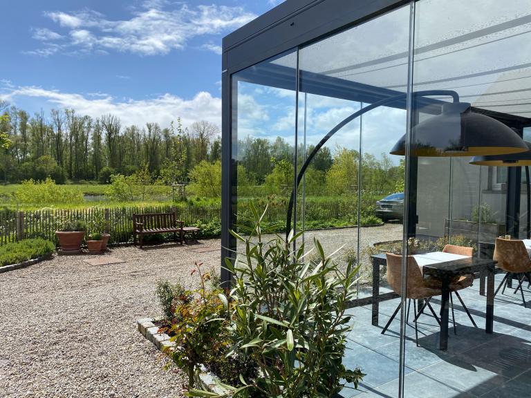 Weinor Terrazza Pure glasoase geplaatst door Demaeght bv aan deze B&B Scheldekant te Oudenaarde. Genieten van het zuid gerichte terras het hele jaar door. Modern en strak design aan deze landelijke woning. Vraag hier uw vrijblijvende offerte op maat. Schuifglas verwarming heatsail Design outdoor Ronse Kluisbergen Deinze Waregem Oostrozebeke Anzegem