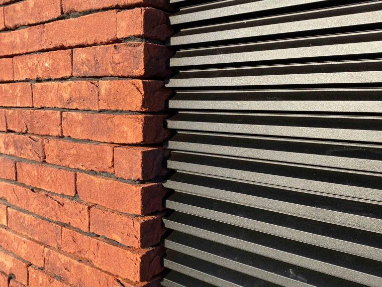 Renson Linius aluminium gevelbekleding geplaatst door Demaeght zonwering aan het sluis van Sint-baafs-vijve. In opdracht van Stadsbader. modern en strak design met deze horizontale aluminium profielen met architecturaal design.