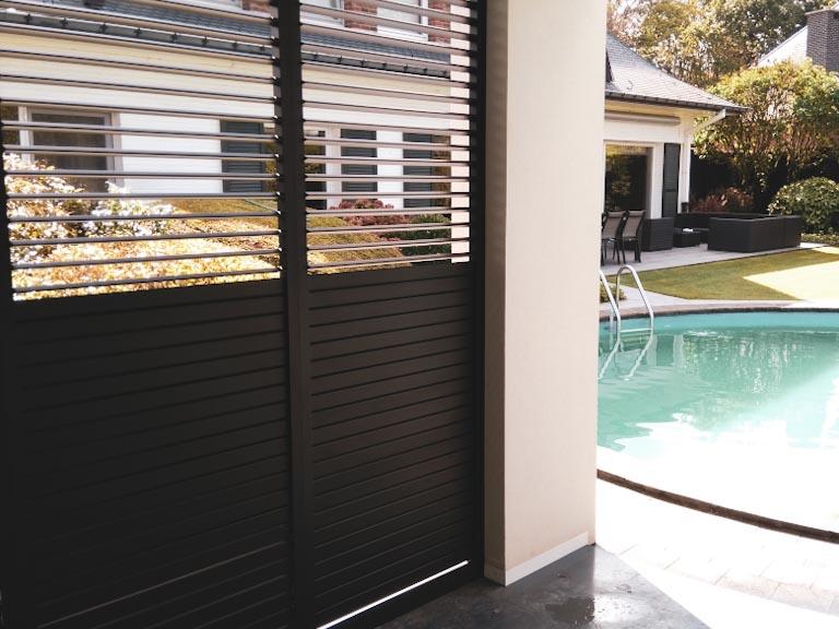 Demaeght Zonwering en interieur plaatste aan deze poolhouse te Antwerpen Renson Linius en Loggialu aluminium panelen. Kwaliteit en design gecombineerd. Gevelbkleding aluminium deur en schuifpanelen.