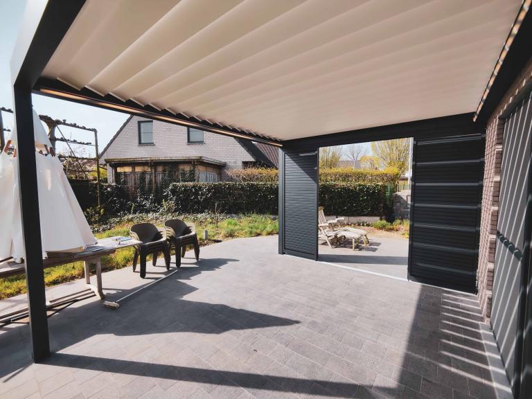 Renson Algarve lamellendak gemonteerd aan de gevel aan deze woning te Harelbeke met geïntegreerde led-verlichting en Loggialu schuifpanelen door demaeght zonwering. Tijdens het bouwen of het verbouwen is het mogelijk om een terrasoverkapping te plaatsen. zo geniet u het hele jaar door van uw tuin en terras. modern strak design architectuur lamellen patio pergola