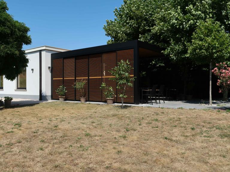 Demaeght Zonwering en interieur plaatste deze Renson Camargue terrasoverkapping aan restaurant La Barriga uit de Pinte. Een modern en strak design tegen een witte crepi gevel van Belgische kwaliteit. Houten schuifpanelen en een aluminium pergola.