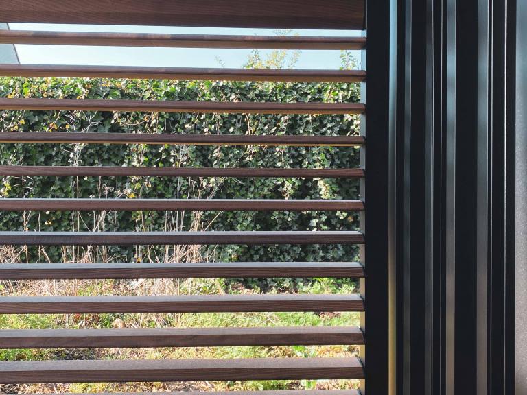 Renson Camargue terrasoverkapping met een houten bijgebouw van Carpentier geplaatst door Demaeght Zonwering & Interieur te Waregem. Met een aluminium lamellendak van Renson kan u het hele jaar door genieten. Architectuur terras design outdoor tuin zonwering zonnewering  