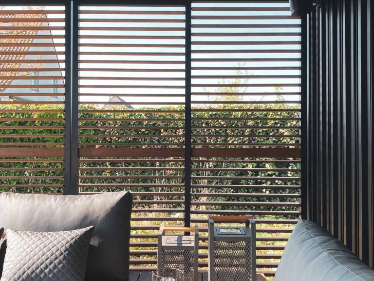 Renson Camargue terrasoverkapping met een houten bijgebouw van Carpentier geplaatst door Demaeght Zonwering & Interieur te Waregem. Met een aluminium lamellendak van Renson kan u het hele jaar door genieten. Architectuur terras design outdoor tuin zonwering zonnewering  