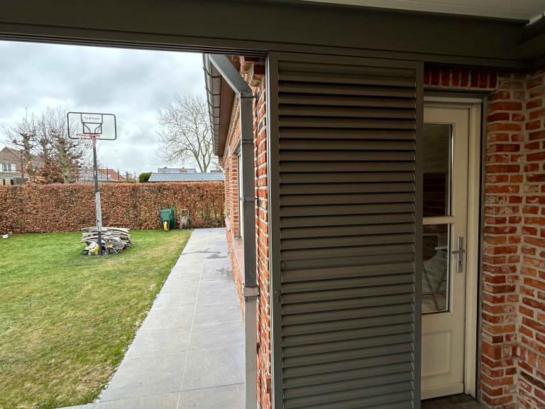 Renson Camargue geplaatst door Demaeght zonwering te Waregem. Een gerenoveerde woning heeft nu een terrasoverkapping gemonteerd aan de woning. Een extra ruimte om te genieten van tuin en terras het hele jaar door. Een strak lamellendak met schuifglas verwarming en led verlichting. Design inspiratie