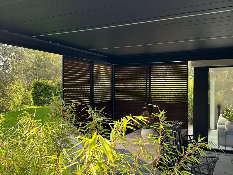 Renton Algarve terrasoverkapping geplaatst door Demaeght zonwering aan deze moderne woning te zulte. Een lamellendak gemonteerd aan de woning. Als optie met houten lamellen en schuifpanelen type Loggia privacy. Modern en strak design van Belgische kwaliteit. Vraag hier uw offerte. Deinze Kortrijk Gent Tielt Oudenaarde Ronse Kluisbergen Anzegem Kruisem Wevelgem Deerlijk