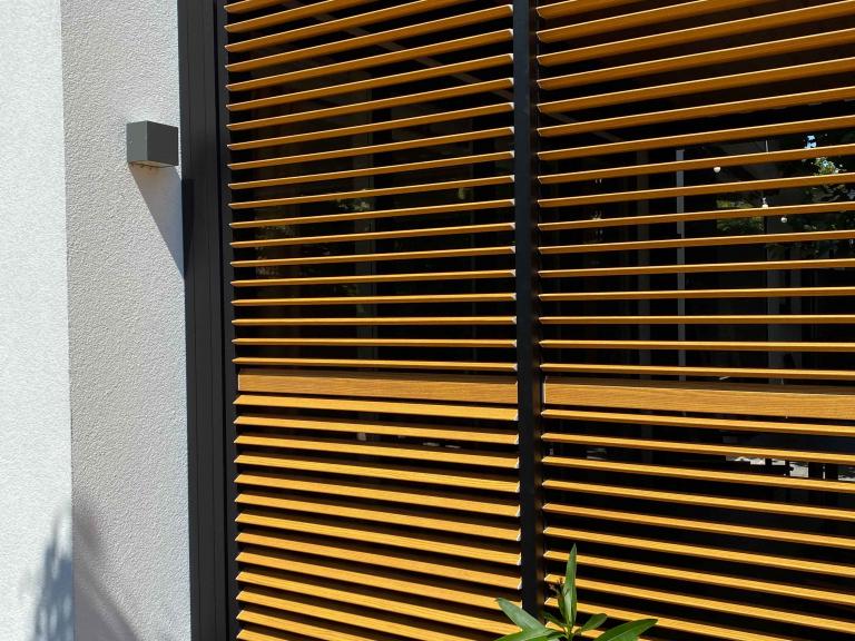 Demaeght Zonwering en interieur plaatste deze Renson Camargue terrasoverkapping aan restaurant La Barriga uit de Pinte. Een modern en strak design tegen een witte crepi gevel van Belgische kwaliteit. Houten schuifpanelen en een aluminium pergola.