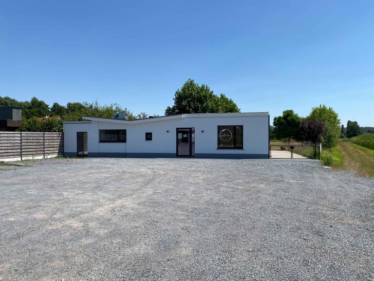 Demaeght Zonwering en interieur plaatste deze Renson Camargue terrasoverkapping aan restaurant La Barriga uit de Pinte. Een modern en strak design tegen een witte crepi gevel van Belgische kwaliteit. Houten schuifpanelen en een aluminium pergola.