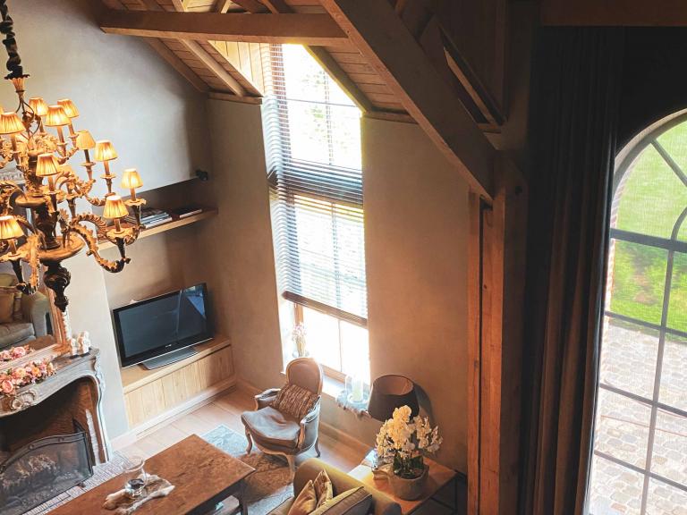 Demaeght zonwering en interieur plaatste deze houten lamellen aan dit groot raam in een landelijke woning te Deerlijk. 