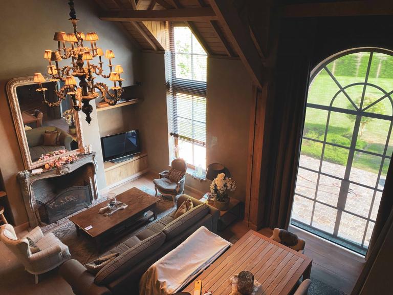 Demaeght zonwering en interieur plaatste deze houten lamellen aan dit groot raam in een landelijke woning te Deerlijk. 