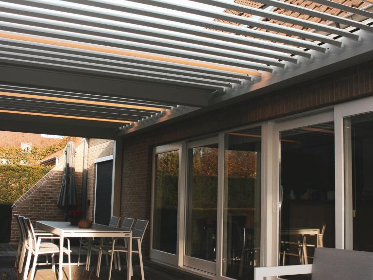 Demaeght zonwering installeerde deze mooie terrasoverkapping te Marke Kortrijk. Door het roteerbaar lamellendak kiest u zelf het lichtinval. Voor extra beschutting kan u kiezen voor windvaste doekzonwering. Zo heeft u een topresultaat in uw pergola.