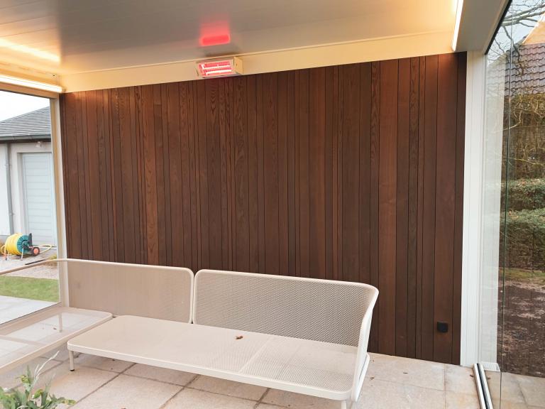 Renson Camargue terrasoverkapping geplaatst op deze mooie locatie te Anzegem als poolhouse aan een zwembad. Met zijn houten achterwand, glazen schuifwanden, led-verlichting en verwarming is dit een full Option lamellendak.