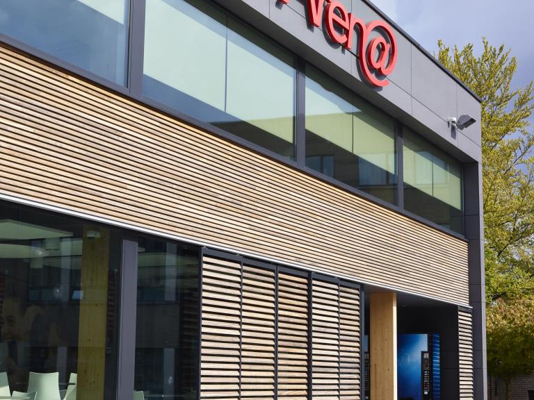 Demaeght Zonwering en interieur plaatste deze houten verschuifbare lamellen van renson aan het Heilig-Hartcollege te Waregem. Renson loggia schuifpanelen hout wood verschuifbaar meerdere panelen