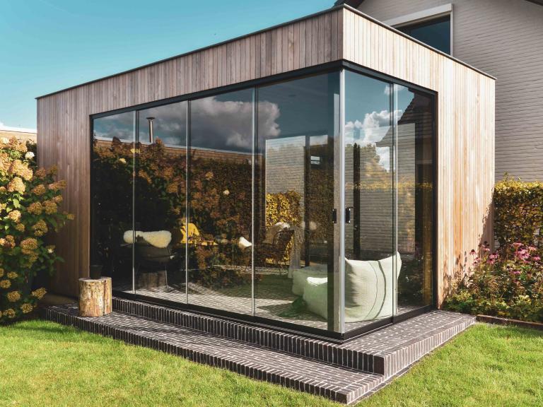 Weinor schuifglas geplaatst door demaeght zonwering voor tuinen Hoornaert te sint-levens-houtem. Een houten buitengebouw of tuinkamer volledig op maat naar wens van de klant. Een mooi outdoor design.