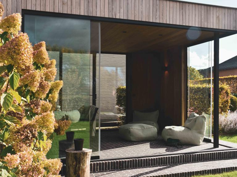 Weinor schuifglas geplaatst door demaeght zonwering voor tuinen Hoornaert te sint-levens-houtem. Een houten buitengebouw of tuinkamer volledig op maat naar wens van de klant. Een mooi outdoor design.
